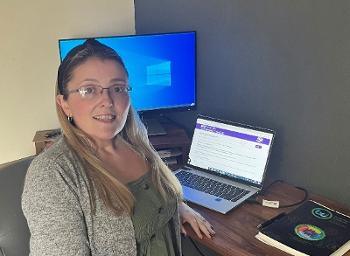 Image of Charlotte McCallum sitting at her desk with laptop