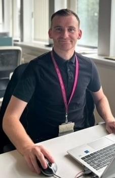 Graeme Crawford at desk smiling to camera