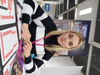 Image of Valerija Tkacenko sitting at a desk with branded materials