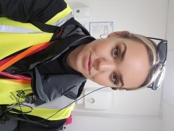 Photo of a young woman wearing yellow hi-vis jacket.