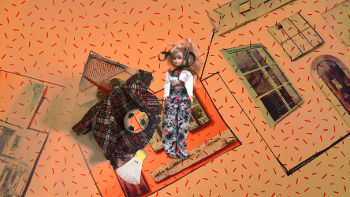 Barbie on an orange background beside some clothes