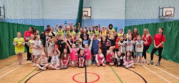 Dozens of children, Street Stuff coaches and Councillor Marie McGurk stand gathered together in a gymhall.