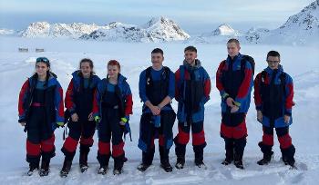 A group of Park Mains High School pupils wearing insulated clothes and standing in a snowy field.