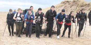 A group of Park Mains High School pupils train to pull sledges on the snow on a beach.