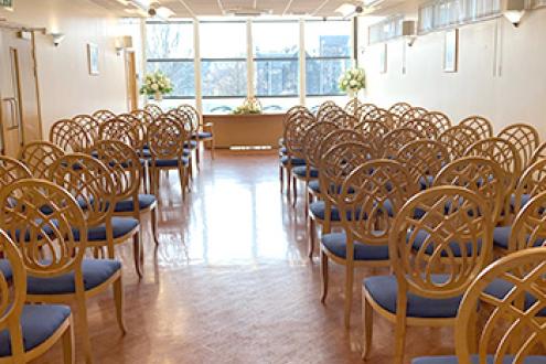 Layout of the Paisley wedding suite with a column of chairs on each side and the registrar's desk in front of the window at the other side of the room.