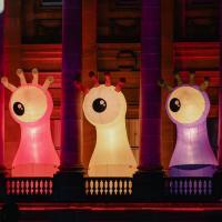Large illuminated creature sculptures displayed on the balcony of Paisley Town Hall during Paisley Halloween Festival, with colourful lighting projected onto the building.
