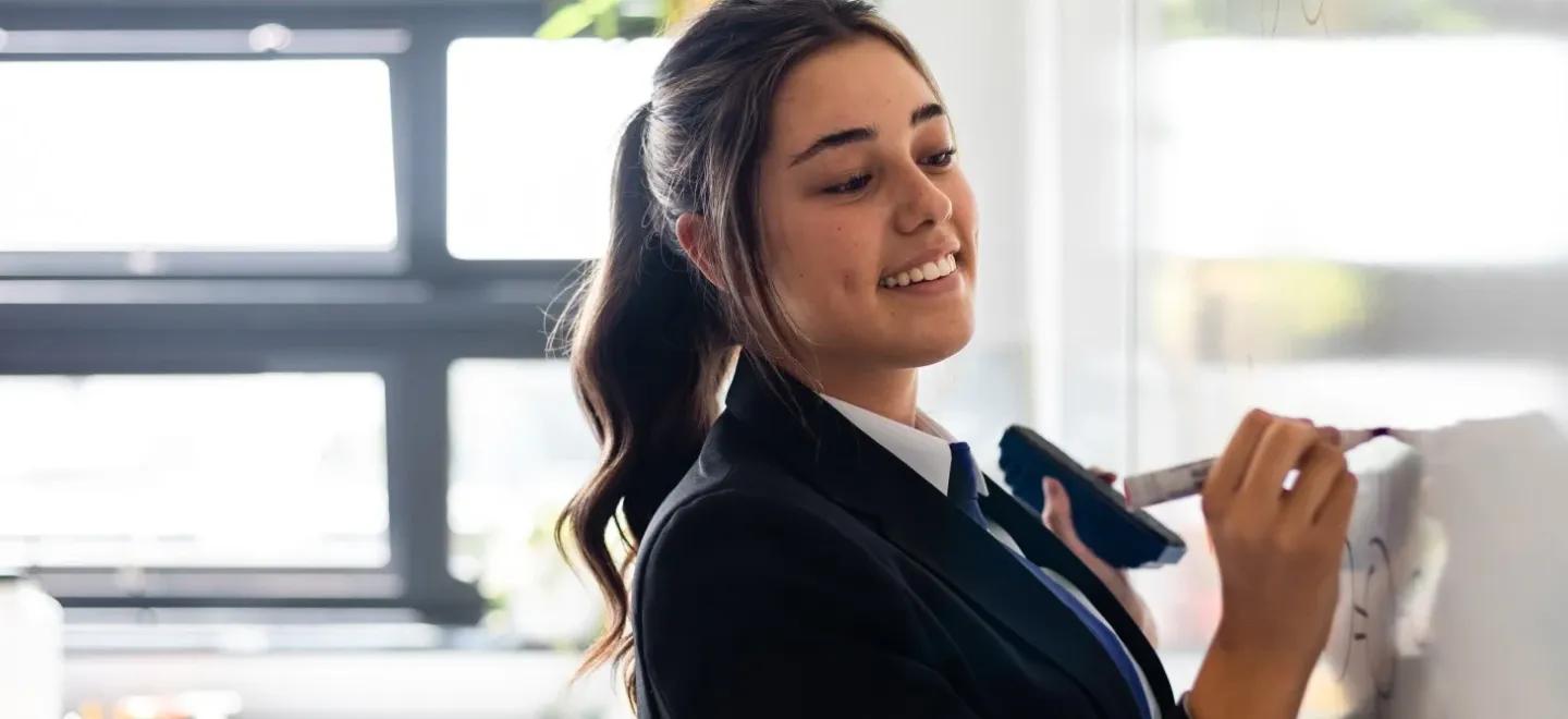 Highschool girl writing on a whiteboard