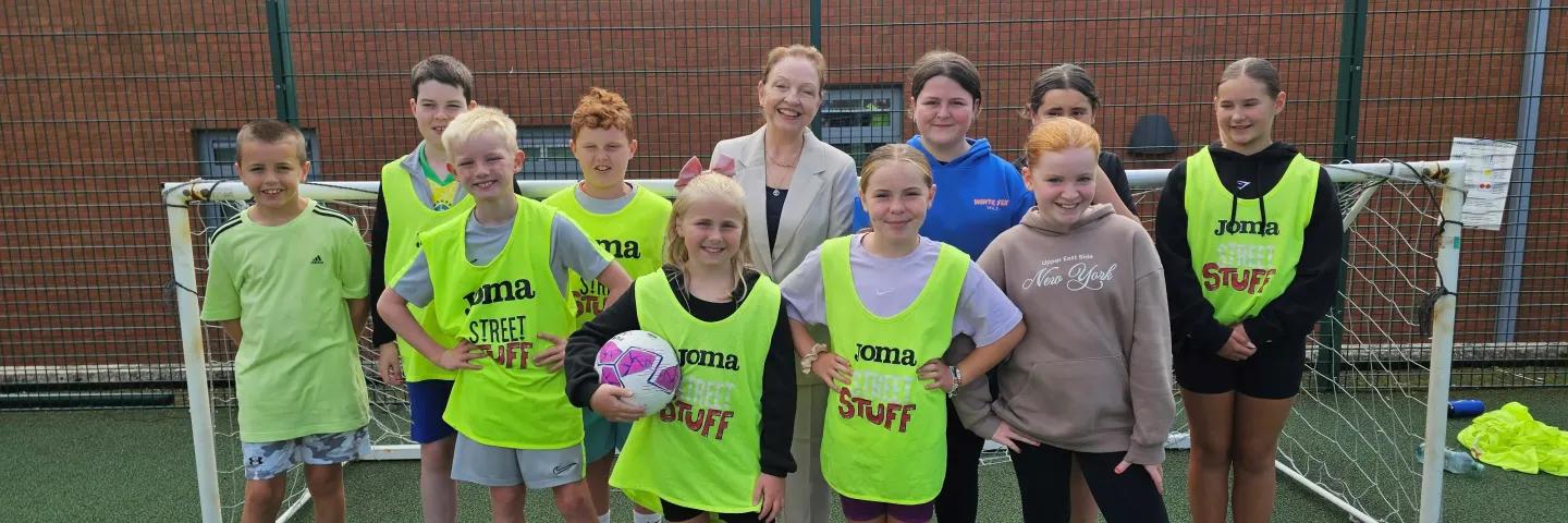 A group of children smiling in front of a football goal