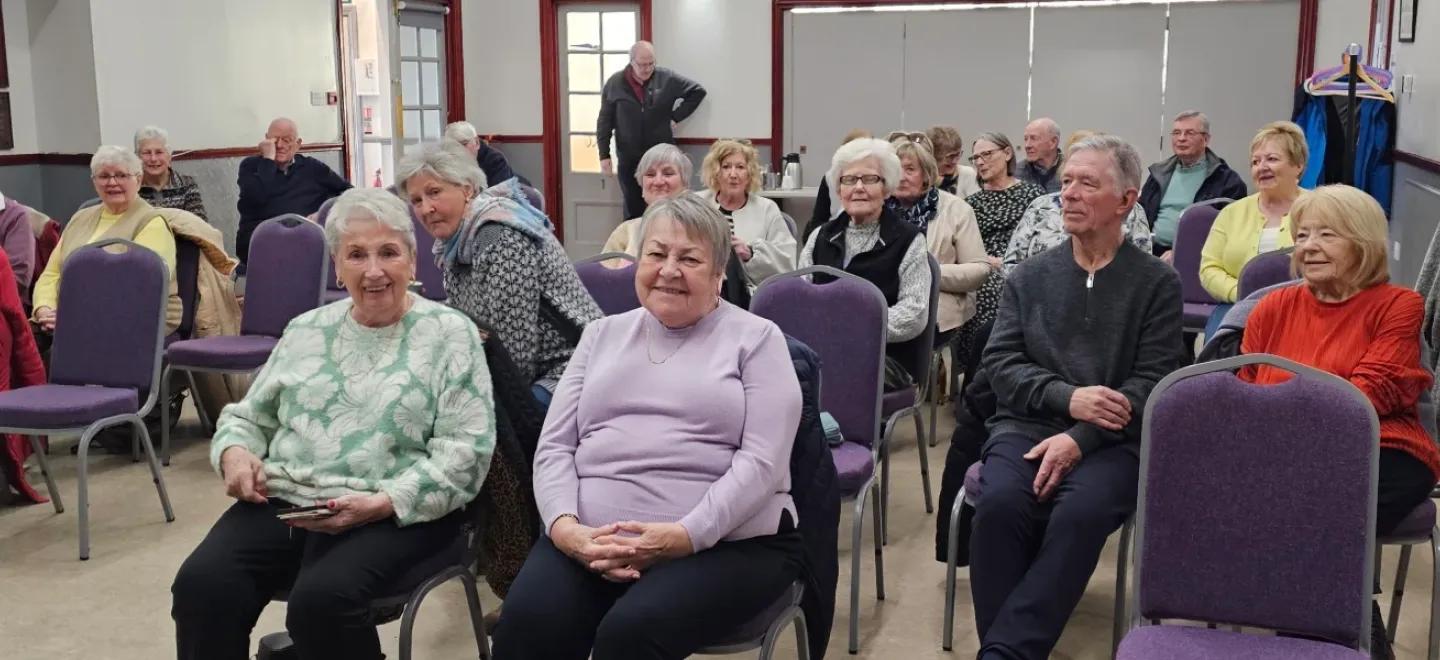 People seated in a large hall to watch a movie.