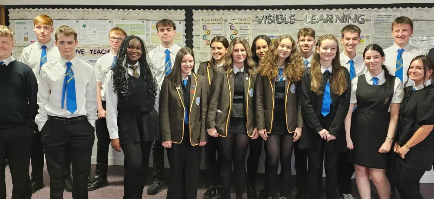 Group of senior pupils and head teacher of Castlehead High School standing together in a classroom.