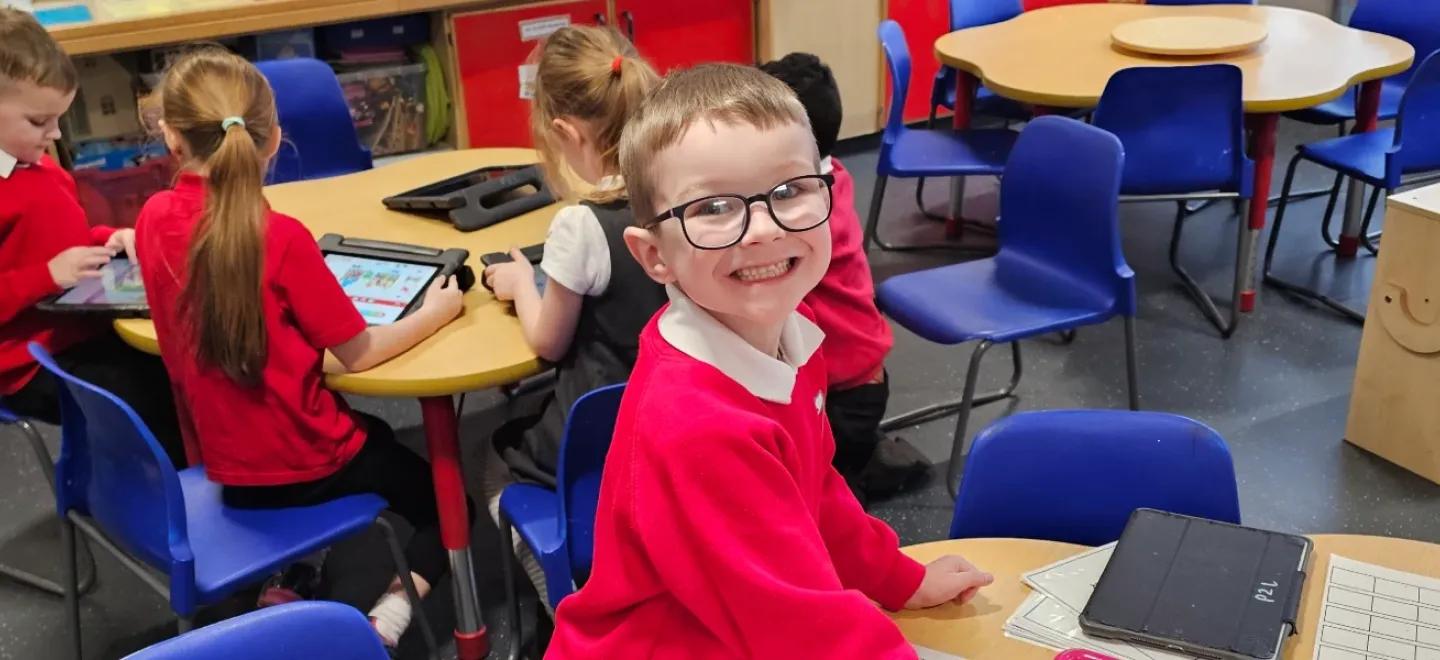 Pupil smiles while learning in a classroom.