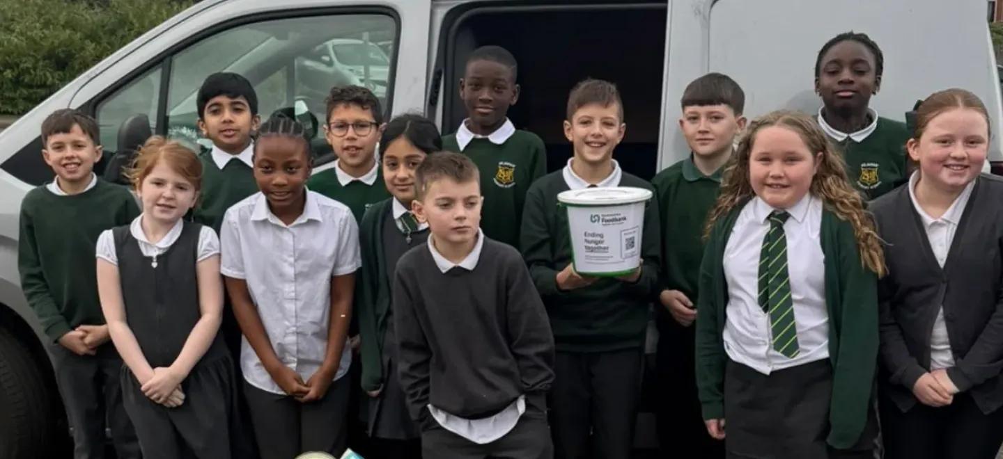 A group of pupils stand together in front of van.