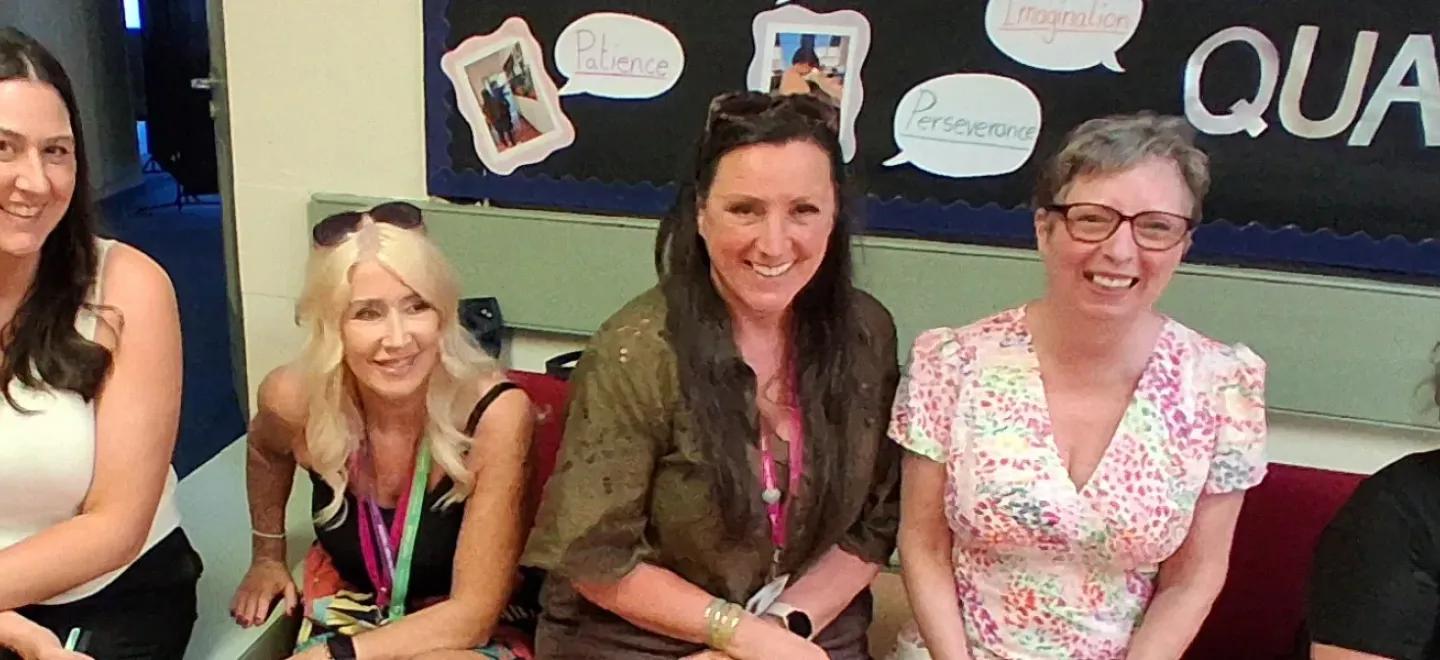 Five people sit together in a room for an event.