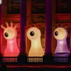 Large illuminated creature sculptures displayed on the balcony of Paisley Town Hall during Paisley Halloween Festival, with colourful lighting projected onto the building.